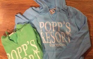 Blue and Green Popp's Resort hooded sweaters.