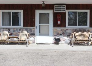 Motel Suite 11 exterior, charcoal grill and wooden chairs