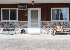 Motel Suite 12 exterior, charcoal grill and wooden chairs
