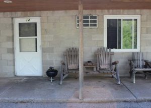 Motel Suite 14 exterior, charcoal grill and wooden chairs