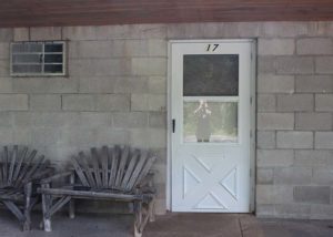 Motel Suite 17 front door and wooden benches.