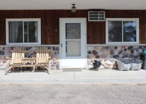 Motel Suite 9 exterior, charcoal grill and wooden chairs